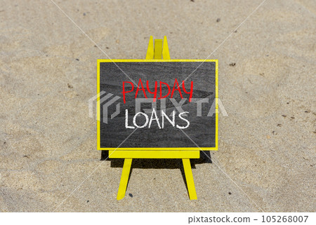 Payday loans symbol. Concept words Payday loans on beautiful black chalk blackboard on a beautiful sand beach background. Business and Payday loans concept. Copy space. 105268007