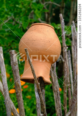 Clay pots are placed on a wooden fence. A beautiful decorative element in the garden. Clay pots are placed on a wooden fence. A beautiful decorative element in the garden. 105268204