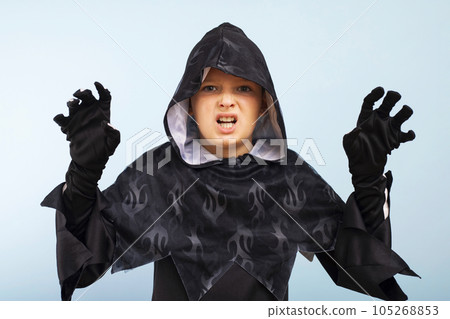Portrait of an angry little boy in a wizard costume on a blue background 105268853