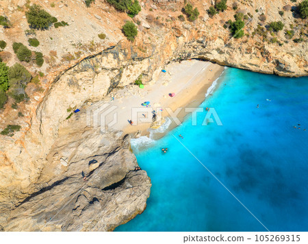 Aerial view of wild beach, blue sea, rock, umbrellas in summer 105269315