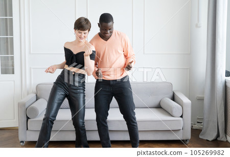 Couple of young man and woman dancing at home 105269982