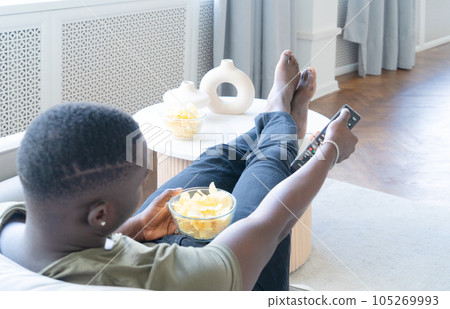 Young man watching TV Young man watching TV 105269993