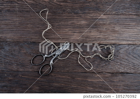 Antique old vintage retro scissors with thread on wooden table. 105270392