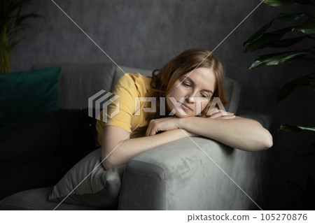 Lost on sad thoughts millennial blonde 30s woman sitting on couch at home feels emptiness by personal difficulties and unsolvable problems, concept of jealous wife, lonely single frustrated female 105270876