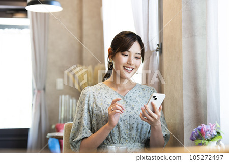 A woman using her smartphone in a cafe 105272497