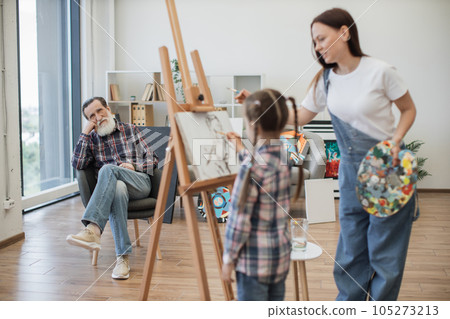 Grandfather enjoying creative process of daughter and kid 105273213