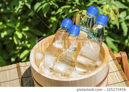 一瓶在夏日強烈陽光下涼爽的彈珠汽水和一個木桶/暑假，昭和復古，日本夏季傳統形象 105273456