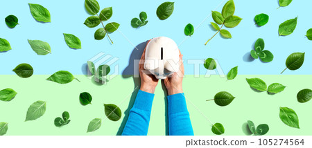 Person holding a piggy bank with green leaves 105274564