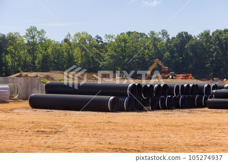 On construction site, stacks of large black plastic pipes ready for sewerage installation. On construction site, stacks of large black plastic pipes ready for sewerage installation. 105274937