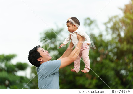 father holding and lifting with his infant baby in park father holding and lifting with his infant baby in park 105274959