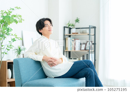 Young man relaxing on a sofa in the living room 105275195