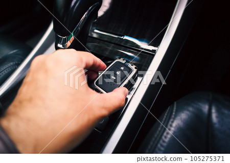 Close up of a driver hand holding a remote control of a car, car keyless entry remote Close up of a driver hand holding a remote control of a car, car keyless entry remote 105275371