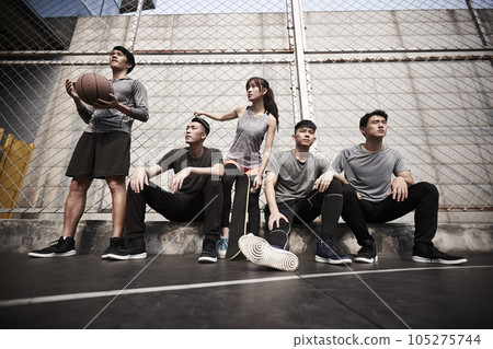 group of five asian young adults men and woman resting relaxing on outdoor basketball court group of five asian young adults men and woman resting relaxing on outdoor basketball court 105275744