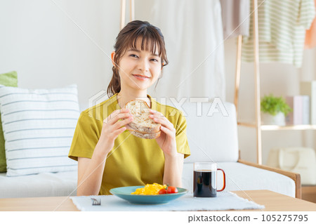 young woman eating breakfast young woman eating breakfast 105275795