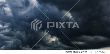The dark sky with heavy clouds converging and a violent storm before the rain.Bad or moody weather sky and environment. carbon dioxide emissions, greenhouse effect, global warming, climate change. 105275828