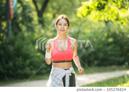 a young woman jogging in a sportswear in a summer morning park 105276824
