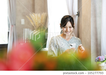 A woman using her smartphone in a cafe 105277793