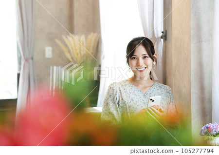 A woman using her smartphone in a cafe A woman using her smartphone in a cafe 105277794
