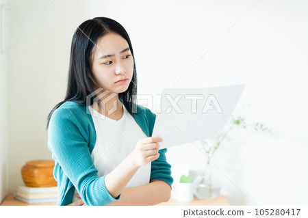 Young woman looking at documents indoors 105280417