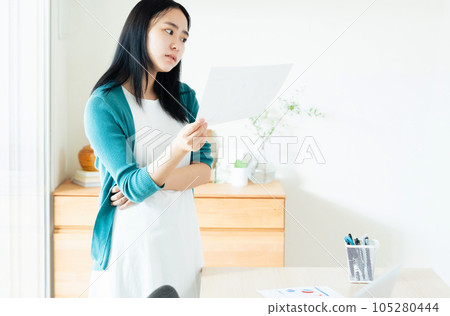 年輕女子在室內查看文件 105280444