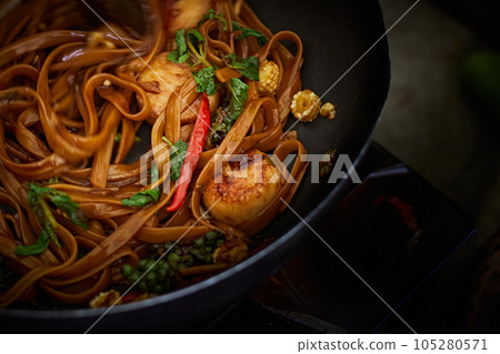 Stir frying Spicy pasta with Scallop in wok 105280571