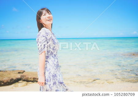 一位穿著裙子的女人在沖繩海灘享受假期 一位穿著裙子的女人在沖繩海灘享受假期 105280709