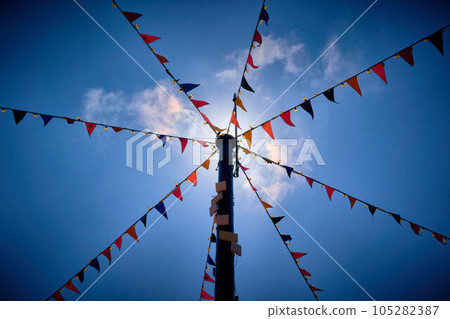 Looking up at bunting flags attached to a pole 105282387