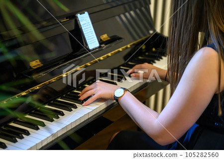Hand playing on schimmel piano at party Event dinner Close-up Small depth of field 105282560