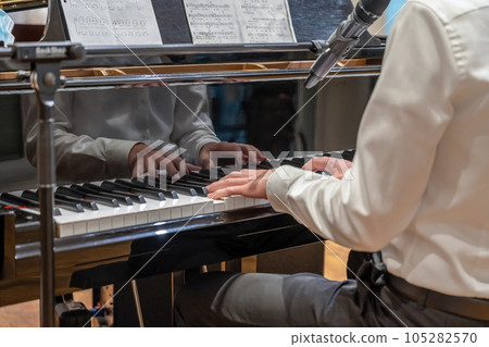 Hand playing on schimmel piano at party Event dinner Close-up Small depth of field 105282570