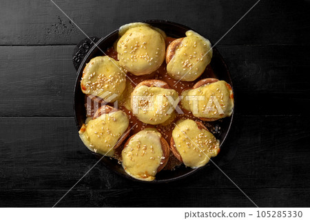 Baked champignon caps stuffed with suluguni in iron pan 105285330