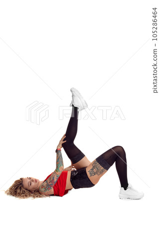 Sexy blond twerk woman with tattoed body and long curly hair is posing in studio. 105286464