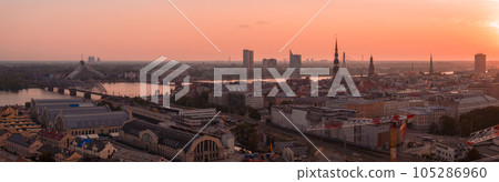 Summer sunset in Riga, Latvia. Aerial view of Riga, the capital of Latvia at sunset. Beautiful buildings, bridges and transport going through the city. 105286960