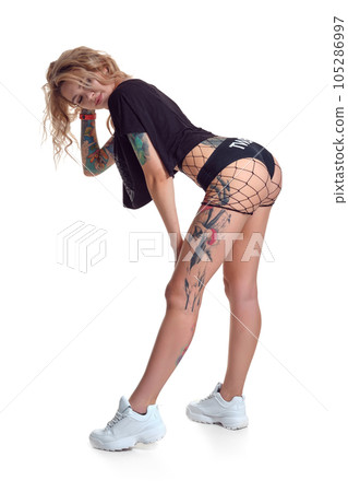 Beautiful blonde dancer woman in booty shorts and fishnet stand backwards isolated on white background Beautiful blonde dancer woman in booty shorts and fishnet stand backwards isolated on white background 105286997