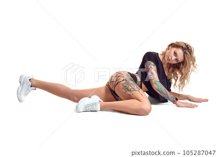 beautiful blonde girl in booty shorts and fishnet dancing twerk isolated on white background 105287047