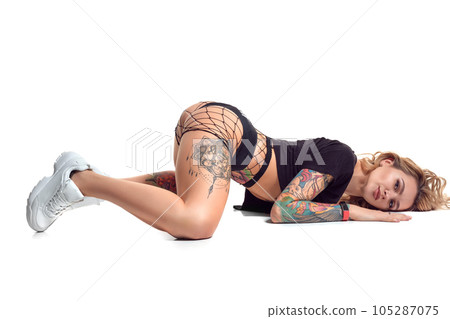 beautiful blonde girl in booty shorts and fishnet dancing twerk isolated on white background 105287075