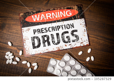 PRESCRIPTION DRUGS. Warning sign with text on wood texture background 105287329