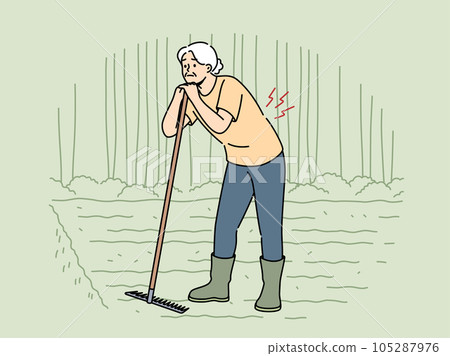 Elderly woman farmer with bad back stands on plantation and leans on rake in need of doctor help Elderly woman farmer with bad back stands on plantation and leans on rake in need of doctor help 105287976