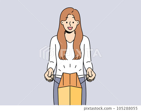 Woman holds paper bag and looks at screen showing off successful shopping and buying goods 105288055