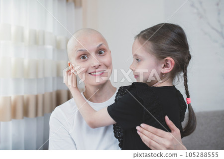 Young smiling woman with oncology is positive about recovery spending time with her daughter 105288555
