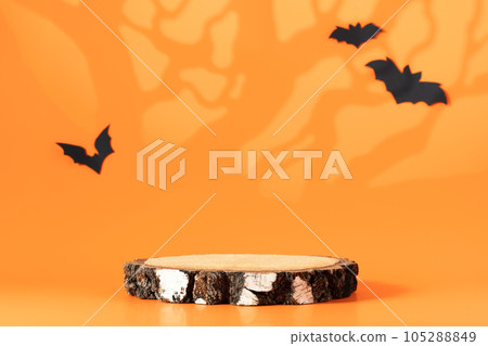 Creative Halloween composition with paper bats, podium and orange background. Modern Halloween aesthetic. 105288849
