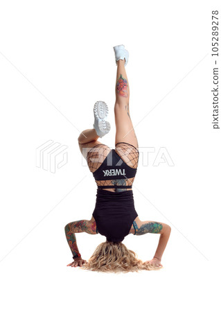 Sexy blond twerk woman with tattoed body and long curly hair is posing in studio. Sexy blond twerk woman with tattoed body and long curly hair is posing in studio. 105289278