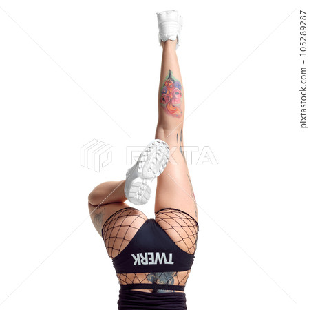 Sexy blond twerk woman with tattoed body and long curly hair is posing in studio. 105289287