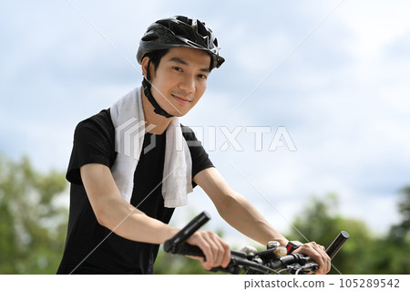 Asian man cyclist in sport clothes and helmet biking in the public park. Sport, outdoors activity and healthy lifestyles 105289542