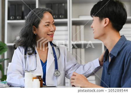 Positive mature doctor giving a consultation to male patient. Medicine and health care concept 105289544