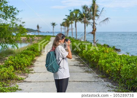 Cute  photographer and  travel blogger taking a photo with camera in summer 105289738