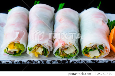 Vietnamese Pho spring roll with seafood, tofu, vegetables isolated on black background for a menu Vietnamese Pho spring roll with seafood, tofu, vegetables isolated on black background for a menu 105289840