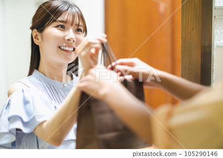 A smiling restaurant clerk handing over the product A smiling restaurant clerk handing over the product 105290146