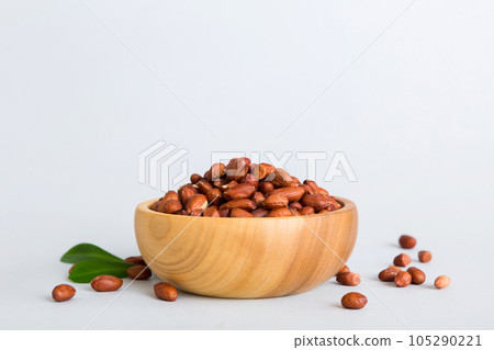 Fresh healthy peanuts in bowl on colored table background. Top view Healthy eating bertholletia concept. Super foods 105290221