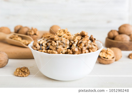 Fresh healthy walnuts in bowl on colored table background. Top view Healthy eating bertholletia concept. Super foods Fresh healthy walnuts in bowl on colored table background. Top view Healthy eating bertholletia concept. Super foods 105290248