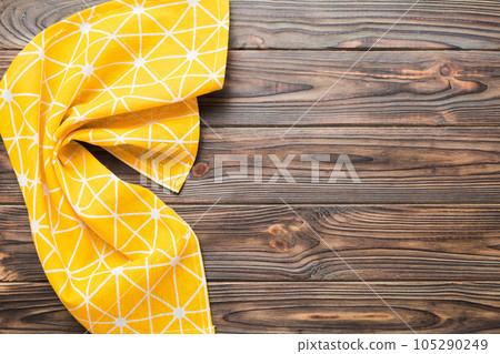 top view with yellow empty kitchen napkin isolated on table background. Folded cloth for mockup with copy space, Flat lay. Minimal style top view with yellow empty kitchen napkin isolated on table background. Folded cloth for mockup with copy space, Flat lay. Minimal style 105290249